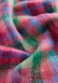 Mehrfarbiger Karostoff mit weichem, flauschigem Material in lebhaften Mustern in Pink-, Grün- und Blautönen. Unregelmäßige Webart.