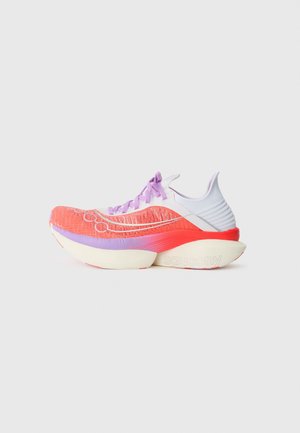 Chaussure de course légère avec tige en mesh corail, lacets violets, semelle blanche épaisse et contrefort de talon blanc sur fond uni.