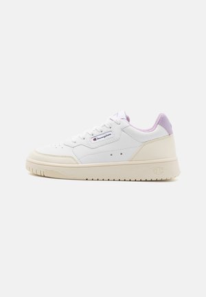 Sneaker bianca in pelle con suola spessa color crema e dettagli color viola pastello sul tallone e sulla linguetta. Presenta un design con fori decorativi.