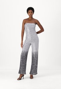 Sølvpaljettdress med stroppeløs design, med en gradvis ombre-effekt til mørkere grå ved kanten og vide ben.