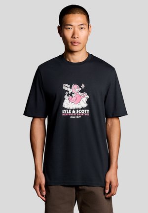 Homme portant un t-shirt noir avec un canard rose de dessin animé tenant une grande brosse à dents au-dessus de bulles blanches, texte indiquant "LYLE & SCOTT Garder la propreté depuis 1874."