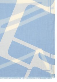 Bufanda azul claro con patrones abstractos blancos, textura suave y bordes con flecos, hecha de un tejido ligero adecuado para superponer.