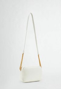 Bílá kožená crossbody taška se měkkým obdélníkovým tvarem, hladkým povrchem a zlatým řetízkem. Minimalistický design, žádné další ozdoby.