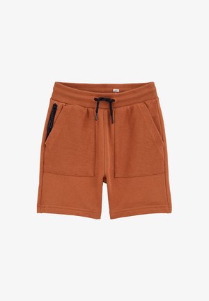 Strickshorts in Rostfarbe mit geripptem elastischem Bund, schwarzem Kordelzug, zwei großen Fronttaschen und einer Reißverschlusstasche auf der linken Seite.