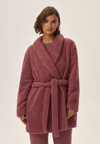 Frotte szlafrok w kolorze mauve z teksturowanym wzorem, kołnierzem w stylu szala, długimi rękawami i paskiem w talii. Wygodny materiał i luźny krój.