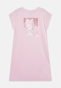 Rosa kortärmad klänning med en kattgrafik som har solglasögon och dekorativa prickar i en rektangulär design. Mjukt tyg, avslappnad passform.