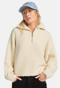 Cremfarbener Fleece-Pullover mit einem halben Reißverschluss am Kragen, strukturierter Stoff, gerippte Akzente am Ausschnitt und lockerer Passform.