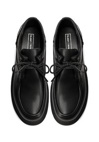 Scarpe in pelle nera con punta arrotondata, design con lacci e texture liscia. Presentano una suola leggermente rialzata e una soletta con marchio.