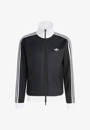 Čierna športová bunda s vysokým golierom, bielym zipsom a bielymi pruhmi na rukávoch. Na hrudi sa nachádza malé biele logo a bočné vrecká.