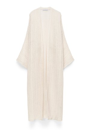 Lange crèmekleurige gebreide cardigan met open voorkant, brede mouwen en een getextureerd verticaal ribbelpatroon.