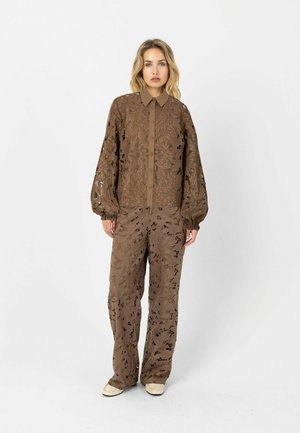 Braunes Blütenspitzenhemd mit Knopfleiste und Ballonärmeln, kombiniert mit passenden Spitzhosen mit ausgeschnittenen Blattmustern.