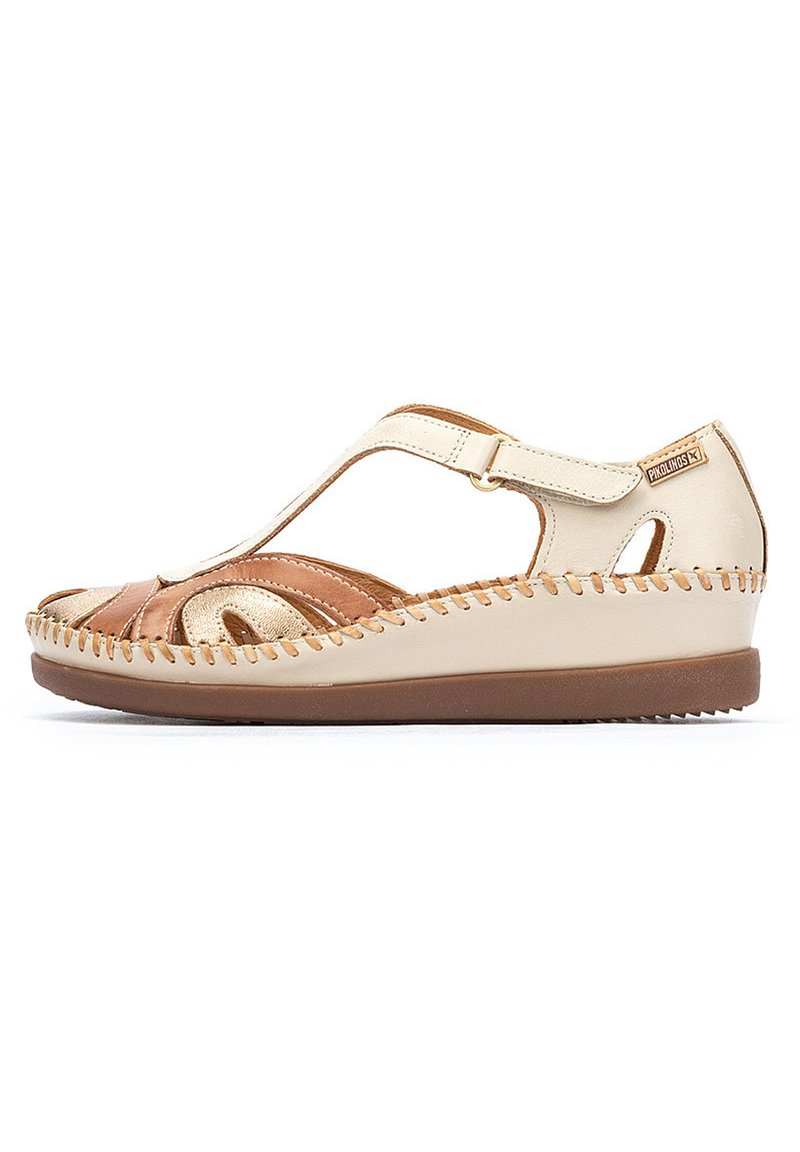 Sandalias en tono beige y crema con un diseño abierto, que cuentan con una parte superior de cuero, tira elástica y detalles de costura a lo largo de la suela.