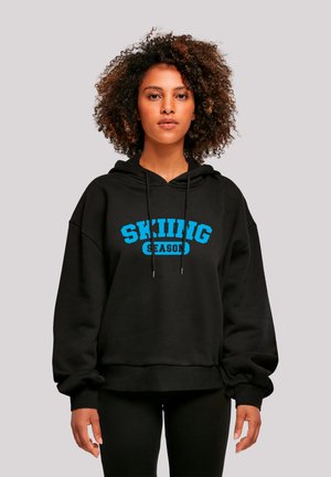 Black hoodie with "SKIING SEASON" in bold blue text. Features a drawstring hood and ribbed cuffs. Made from soft, warm fabric.