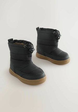 Botas aisladas negras con diseño acolchado, cordón elástico y suela de goma. Cuentan con un interior suave y puntera reforzada.