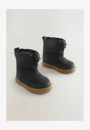 Melni izolēti zābaki ar kviltētu dizainu, elastīgu auklu un gumijas zoli. Iezīmējas ar mīkstu iekšējo oderi un pastiprinātu purngalu.