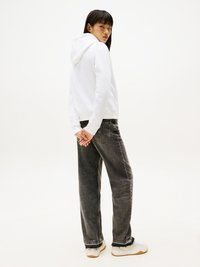 Sudadera blanca con capucha, jeans gris de pierna ancha, zapatillas blancas con suelas de goma. Enfóquese en la silueta relajada y las texturas de tela contrastantes.