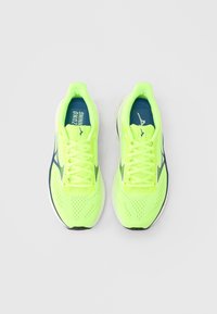 Λαμπερά πράσινα νέον αθλητικά παπούτσια με επάνω μέρος από διαπνέον δίχτυ, αντιθετική σκοτεινή μπλε εσωτερική σόλα και λευκές λεπτομέρειες στα πλευρά.