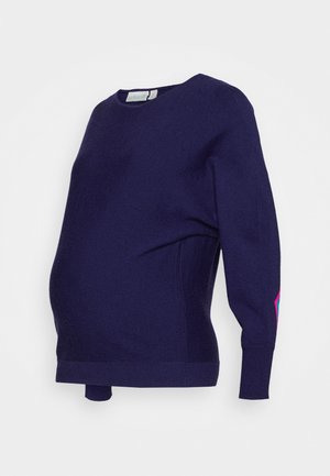 Mørkeblå graviditetstrøje i blødt stof, rund halsudskæring, lange ærmer, med en farverig detalje på venstre ærme og en afslappet pasform.