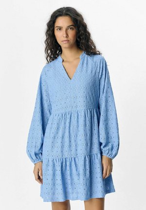 Hellblaues Kleid mit V-Ausschnitt, langen Puffärmeln und mehrlagigem Rock. Hergestellt aus strukturiertem Stoff mit rautenförmigen Mustern und Ausschnitten.
