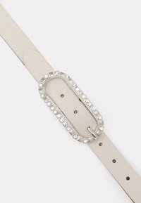 Ceinture en cuir blanc avec une boucle ovale en argent, bordée de strass transparents. Ajustable avec plusieurs trous pour la taille.