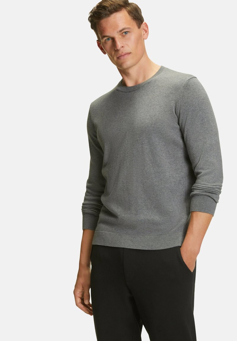 Grauer Rundhalsausschnitt-Pullover aus weichem Stoff mit langen Ärmeln und gerippten Bündchen und Saum, kombiniert mit schwarzen Hosen, auf einem neutralen Hintergrund präsentiert.