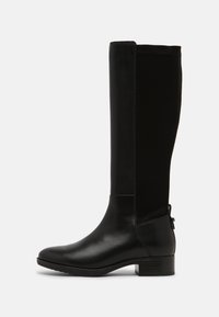 Botas negras hasta la rodilla que combinan cuero liso y ante, con un tacón cuadrado y un tirador lateral para ponérselas fácilmente.