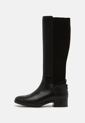 Stivali neri al ginocchio realizzati in una combinazione di pelle liscia e camoscio, con tacco a blocco e una linguetta laterale per facilitarne l'indossamento.