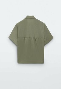 Chemise vert olive à manches courtes avec un empiècement au dos et un détail froncé en dessous.