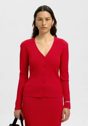 Rote gerippte Strickjacke mit V-Ausschnitt, langen Ärmeln und fünf vorderen Knöpfen, kombiniert mit einem passenden Midirock. Glatte Textur.