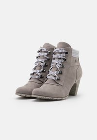 Botas de tobillo de ante gris con tacón apilado, que presentan cordones a rayas en blanco y negro y un detalle de puño a rayas a juego.