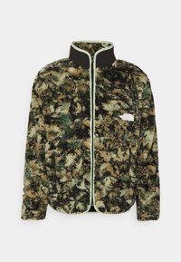 Fleecejacke mit grünem, braunem und schwarzem abstraktem Muster; schwarzer Kragen; hellgrüner Reißverschluss; zwei vordere Reißverschlusstaschen. Logo auf der Brust.