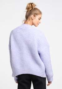 Lavendelstickad tröja med ett strukturerat mönster, oversized passform och ribbade ärmslut. Mjuk, fluffig materia med en avslappnad silhuett.