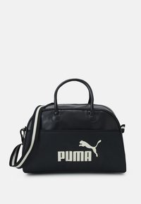 Sort duffel bag har en glat lædertop, stofbund, dobbelte håndtag og en aftagelig stribet skulderrem. Viser et stort hvidt PUMA-logo.