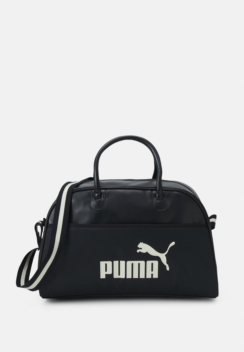 Sort duffel bag har en glat lædertop, stofbund, dobbelte håndtag og en aftagelig stribet skulderrem. Viser et stort hvidt PUMA-logo.