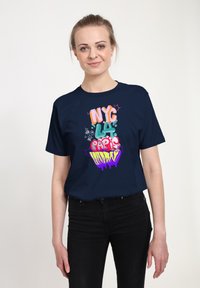 Námořnické modré tričko s barevným grafickým nápisem "NYC LA Paris Sunday" v různých písmových stylech. Bavlněný materiál, krátké rukávy, uvolněný střih.