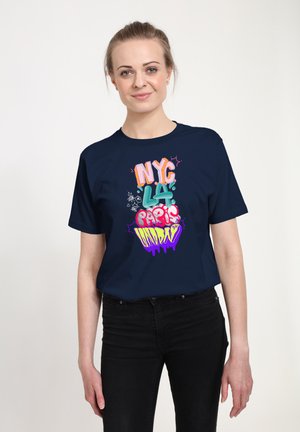 Námořnické modré tričko s barevným grafickým nápisem "NYC LA Paris Sunday" v různých písmových stylech. Bavlněný materiál, krátké rukávy, uvolněný střih.