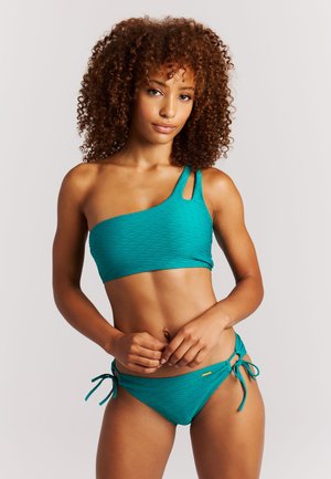 Turquoise bikinitop met één schouder en een gestructureerde stof, met een uitgesneden detail. Bijpassende lage bikinibroek met zijstrikjes.