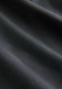 Textile fabric in black, featuring a smooth texture with a slightly lustrous sheen and subtle ribbed pattern.
