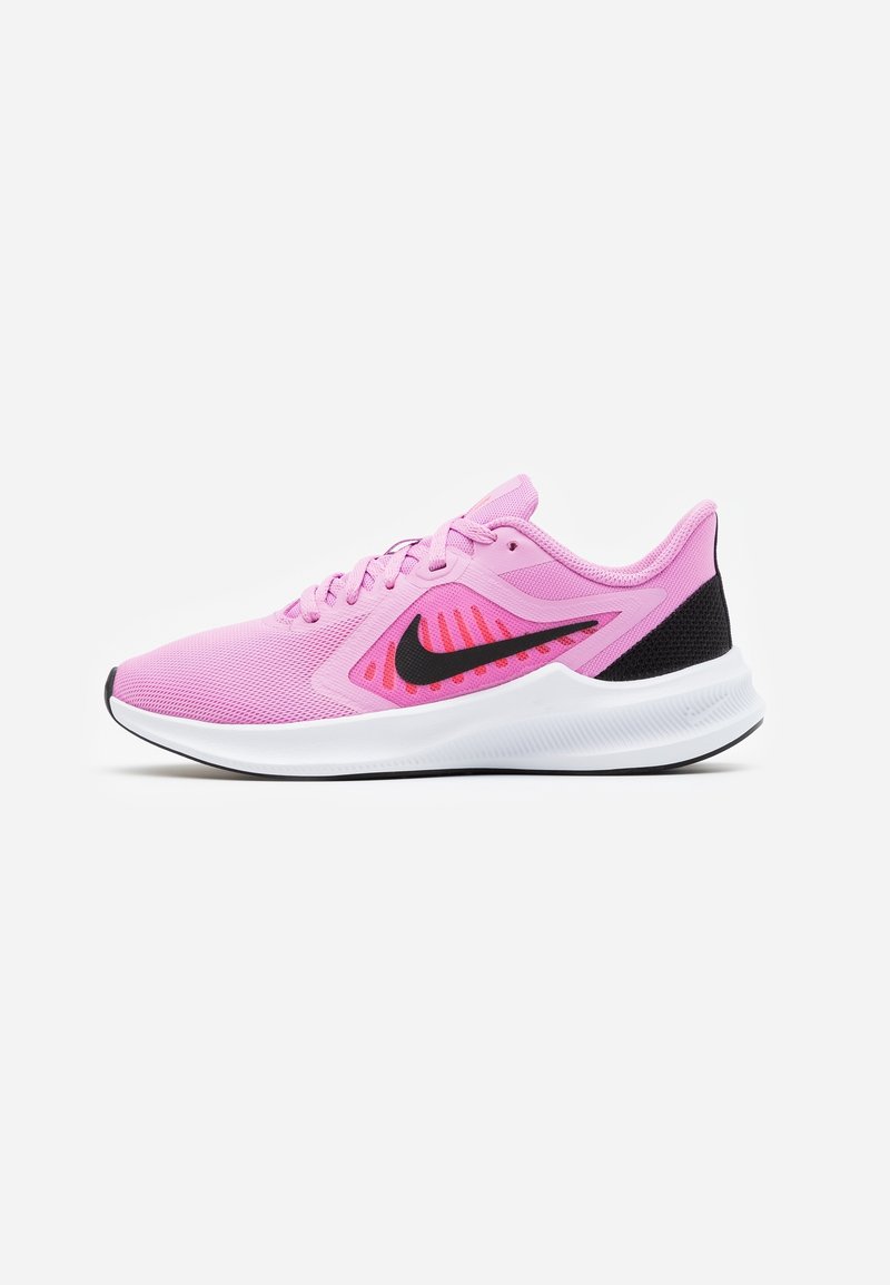 Chaussure de course rose clair avec le logo Nike noir, semelle blanche et détail noir au talon, vue de côté sur un fond blanc.