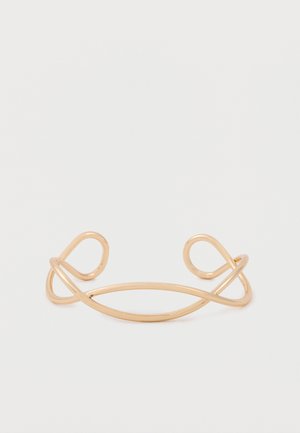 Minimalist open gold cuff bracelet with two symmetrical loops on each end, displayed on a plain white background.