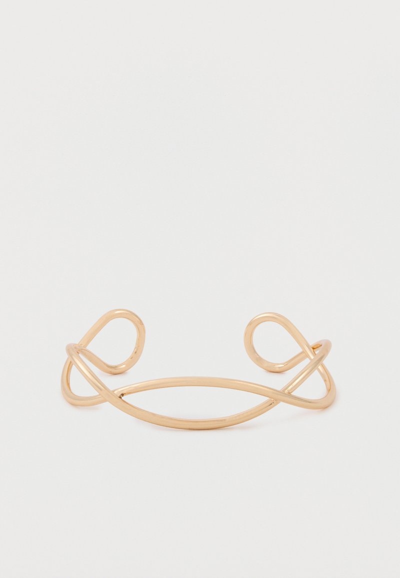 Μινιμαλιστικό ανοιχτό βραχιόλι από χρυσό με δύο συμμετρικούς βρόχους σε κάθε άκρο, τοποθετημένο σε απλό λευκό φόντο.