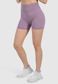Pantaloni sportivi a vita alta in lavanda, realizzati in tessuto elasticizzato, caratterizzati da una superficie liscia e un design sagomato per il comfort durante l'esercizio.