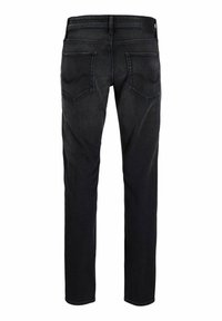 Jeans de mezclilla negros vistos desde atrás con dos bolsillos traseros, pasadores para el cinturón y una etiqueta de cuero de la marca en la cintura.