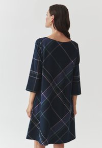 Robe marine à manches trois-quarts, présentant un grand motif à carreaux dans des teintes de vert, violet et rose, avec une silhouette A-line ample.