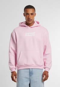Pink hooded sweatshirt made of soft fabric, featuring a front kangaroo pocket and the text "sweet treats" in white. Ribbed cuffs and hem.
