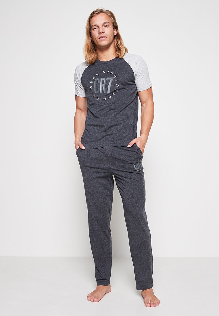 Szary t-shirt z krótkim rękawem ma okrągły dekolt oraz kontrastowe jasnoszare rękawy; zestawiony z ciemnoszarymi spodniami dresowymi z logo.