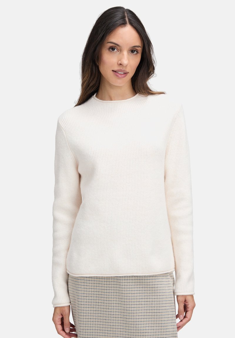 Sweter w kolorze kremowym, prążkowany, z długimi rękawami i okrągłym dekoltem, w połączeniu z spódnicą w kratę. Miękka tekstura, minimalistyczny design, dopasowany fason.