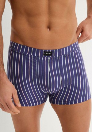 Boxers à rayures marines avec des rayures pastel verticales, taille élastique avec une étiquette noire portant l'inscription "CASUAL", fabriqués en tissu doux.