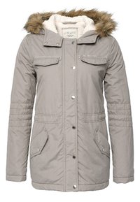 Šedá puffy bunda s kapucí z umělé kožešiny, předními knoflíky, dvěma náprsními kapsami a dvěma postranními kapsami. Obsahuje žebrované detaily na rukávech.