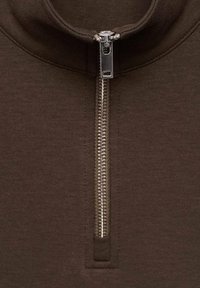 Maglione zip-up marrone con colletto alto, dotato di una robusta cerniera argentata e texture a coste su tutta la superficie. Design semplice e funzionale.